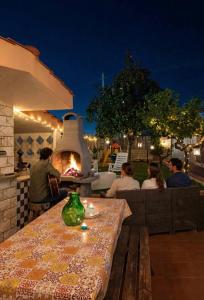 a group of people sitting at a table with a fireplace at Villa Daisy Conversano-Polignano a Mare in Conversano