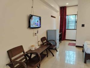 a living room with chairs and a table and a tv at Erawan Place in Mae Sot +56 photos