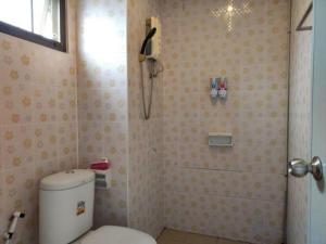 a bathroom with a toilet and a phone on the wall at Erawan Place in Mae Sot