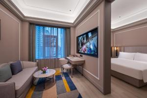 a hotel room with a bed and a couch at Mercure Kunming Wujiaba in Kunming +54 photos
