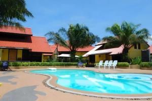 a swimming pool in a resort with chairs and trees at Tanisa Resort in Na Dhung
