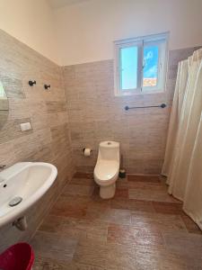 a bathroom with a toilet and a sink and a window at Vittoria House Garden in Bayahibe