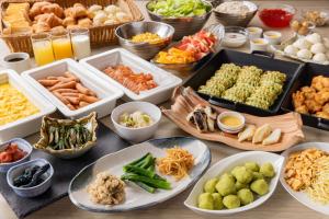 a table topped with trays of different types of food at Hotel Keihan Sendai in Sendai