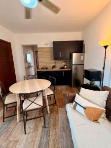 a living room with a table and a kitchen at Vittoria House Garden in Bayahibe +5 photos