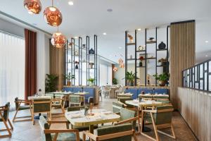 a restaurant with tables and chairs and windows at Courtyard by Marriott Sheffield in Sheffield