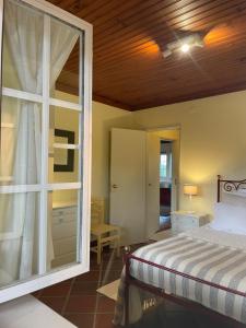 a bedroom with a bed and a large window at Casas do Alpendre in Óbidos +51 photos
