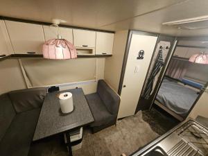 a small room with a table and a couch and a bed at Full Service Caravan 1 in Albertslund