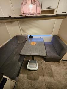 a small seat in a trailer with a table at Full Service Caravan 1 in Albertslund