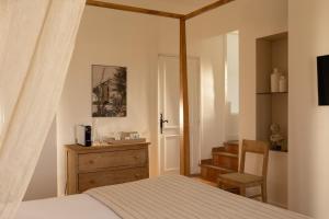 a bedroom with a bed and a dresser and a staircase at La Regalido in Fontvieille