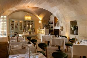 a restaurant with white tables and chairs in a room at La Regalido in Fontvieille