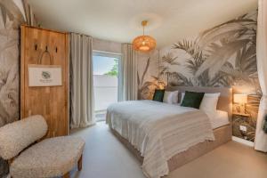 a bedroom with a bed and a chair and a window at BALI BLIZZ - App 15 in Benz