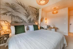 a bedroom with a large white bed with green pillows at BALI BLIZZ - App 15 in Benz +16 photos