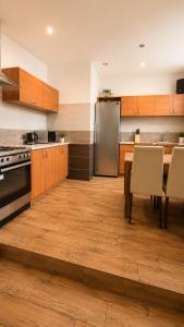 a kitchen with a table and a stainless steel refrigerator at Pokoje Bielsko in Bielsko-Biała +5 photos