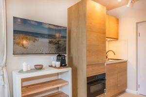 a kitchen with wooden cabinets and a painting on the wall at BALI BLIZZ - App 16 in Benz
