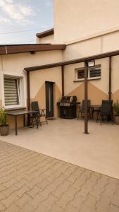 a patio with tables and chairs and a grill at Pokoje Bielsko in Bielsko-Biała