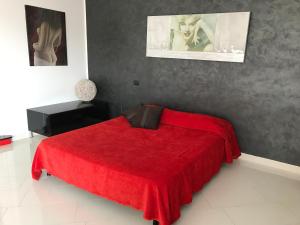 a bedroom with a red bed with a red blanket at Prestige Loft Taormina in Taormina