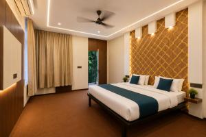 a bedroom with a large bed and a ceiling fan at Atithi Farms - 4 BHK Farm Villa with Private Pool in Thūr