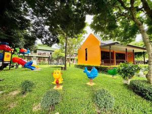 a playground with play equipment in the grass at Doembang Villa in Ban Tha Pong