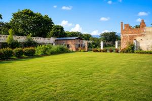 a large lawn in front of an old building at Atithi Farms - 4 BHK Farm Villa with Private Pool in Thūr