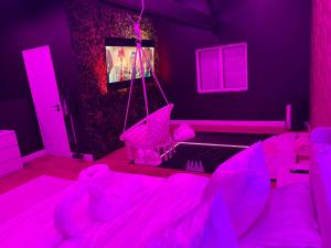 a pink room with a bed with pink lights at La Suite Prestige in Saint-Quentin