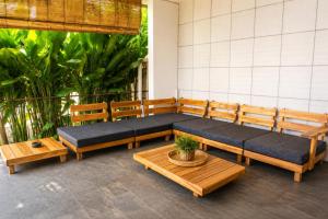 a seating area with benches and a table at Empat Bintang Villas in Uluwatu +24 photos