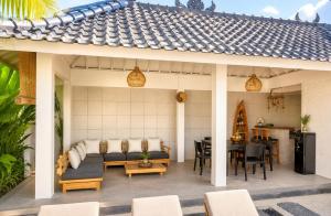 a patio with a couch and a table at Empat Bintang Villas in Uluwatu