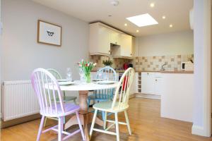 a kitchen and dining room with a table and chairs at Fig Cottage, near Bradford on Avon and Bath in Holt