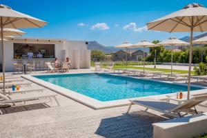 a swimming pool with lounge chairs and umbrellas at Terra Vinum in Neméa
