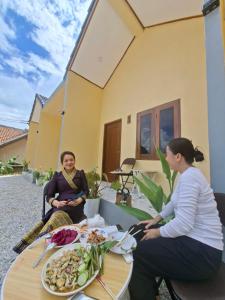 two women sitting at a table with a plate of food at Sokmoungkhoun in Nongkhiaw