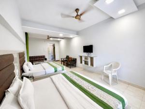 a hotel room with two beds and a tv at Hotel SVD HARIDWAR in Haridwār