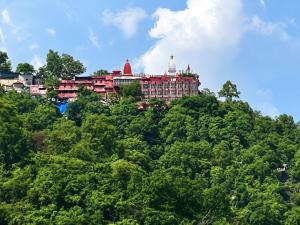 a building on top of a hill with trees at Hotel SVD HARIDWAR in Haridwār
