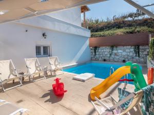 a backyard with a slide and a swimming pool at Marelia Memories villa in Skaleta