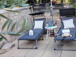 two blue chairs and a table on a patio at Gîte Lavande - Le Jardin Secret du Ventoux in Modène