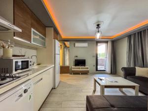 a kitchen and a living room with a table at Easy Stay Mia Suites in Aydın