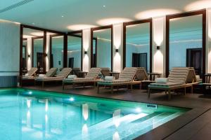 a hotel swimming pool with lounge chairs and a swimming pool at J.K. Place Paris in Paris