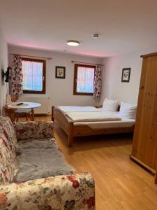 a bedroom with a bed and a couch and a table at Hotel Maien in Todtmoos in Todtmoos