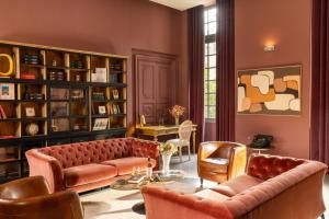 a living room with a couch and chairs and bookshelves at Margaret - Hôtel Chouleur in Nîmes