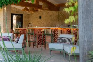 a patio with chairs and a bar in a building at Le Mas de Guilles in Lourmarin