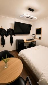 a room with a bed and a table and a tv at 힐링모텔 in Inch'ŏn-yŏk