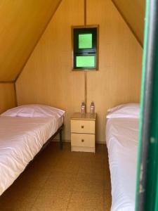 a bedroom with two beds and a window and a night stand at Campimeco by Campigir in Alfarim +32 photos