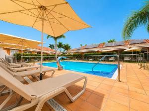 a pool with two lounge chairs and an umbrella at Alsol Los Leones Bungalows - Adults Only in Maspalomas