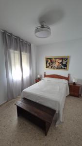a bedroom with a large bed with a white bedspread at Apartamento con Garaje, WiFi, Centro y playa in Chipiona