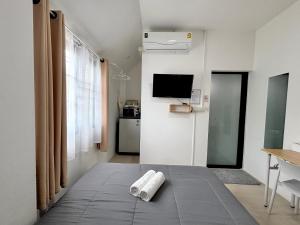 a room with a bed with two towels on it at D sleep Home Chiangmai in Chiang Mai