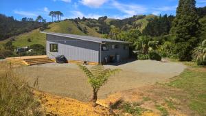 a small house in the middle of a yard at Ocean Cliff Court in Kuaotunu