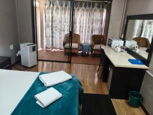 a room with a bed with two white towels on it at Blyde Lodge in Graskop