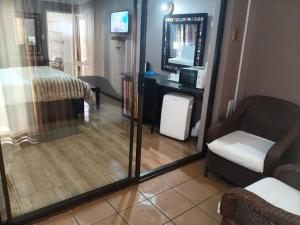 a room with a mirror and a chair and a bed at Blyde Lodge in Graskop