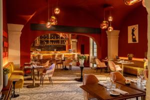 a restaurant with red walls and tables and chairs at Margaret - Hôtel Chouleur in Nîmes
