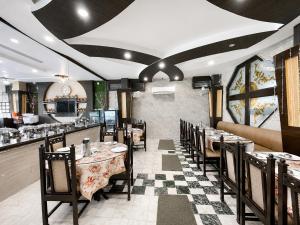 a dining room with tables and chairs in a restaurant at Hotel SVD HARIDWAR in Haridwār