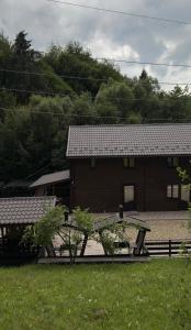 a wooden building with a picnic table in front of it at Садиба Володар in Kosiv