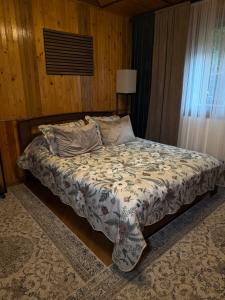 a bedroom with a bed with a comforter on it at Садиба Володар in Kosiv
